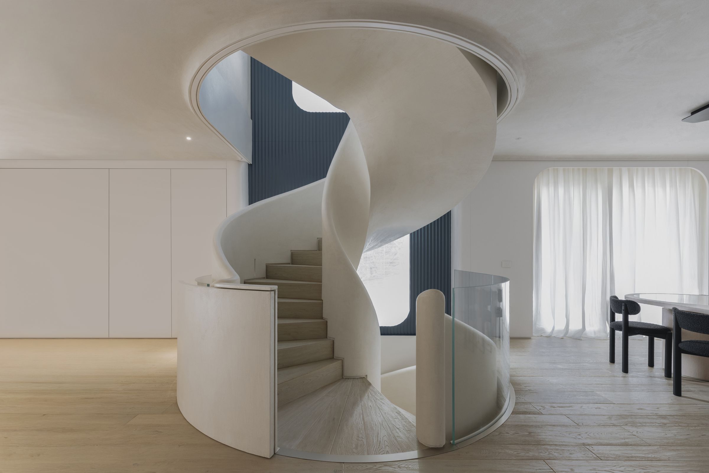 Helical staircase and white fitted walls in Villa D.F.